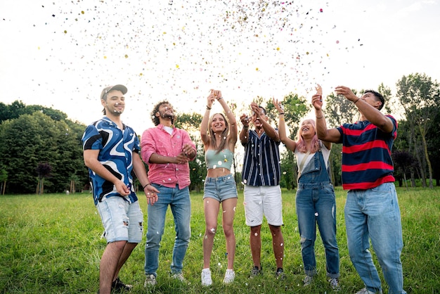 Grupo de adolescentes multiétnicos passando tempo ao ar livre em um piquenique no parque