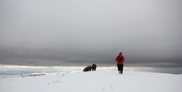 Grupo de alpinistas caminhando pelas montanhas cobertas de nevexAxA