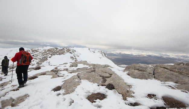 Grupo de alpinistas caminhando pelas montanhas cobertas de nevexAxA