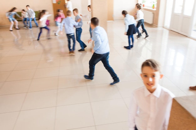 Grupo de alunos correndo felizes no intervalo. Desfoque de movimento na atividade física