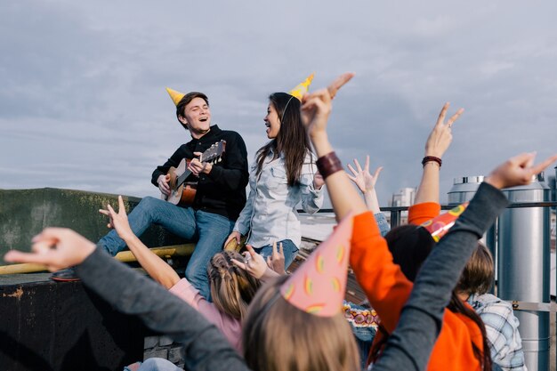 Grupo de alunos em festa ao vivo. Amigos companhia lá fora com violão, feliz aniversário