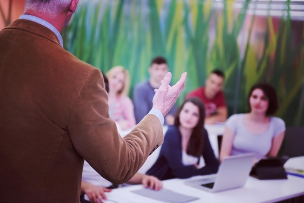 grupo de alunos estudam com professor na sala de aula da escola moderna