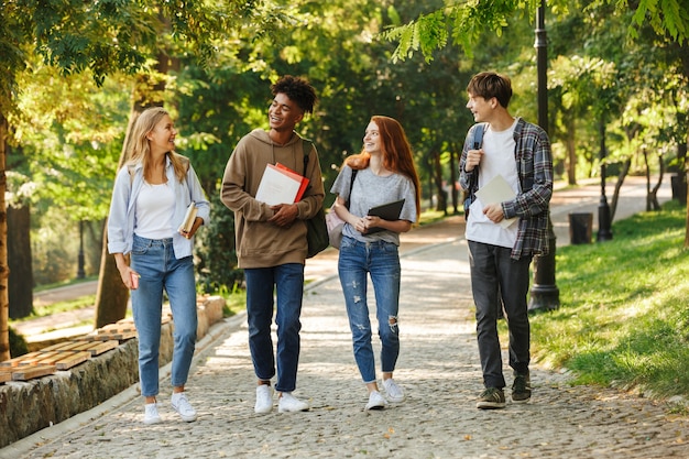 Grupo de alunos felizes caminhando pelo campus