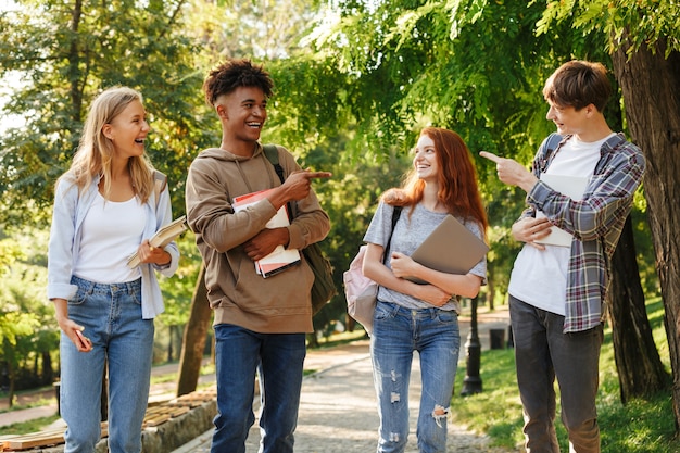 Grupo de alunos rindo caminhando pelo campus