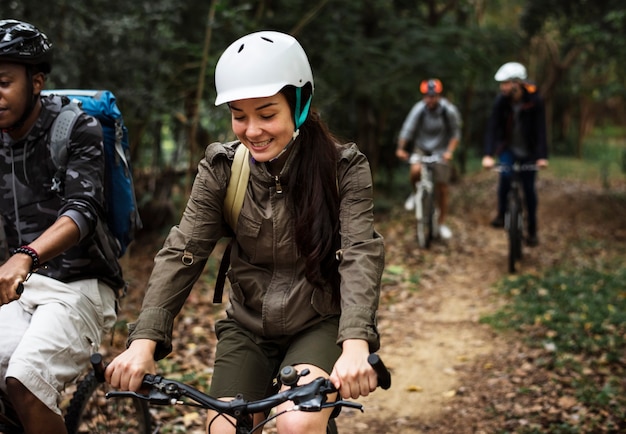 Grupo de amigos andando de mountain bike na floresta juntos