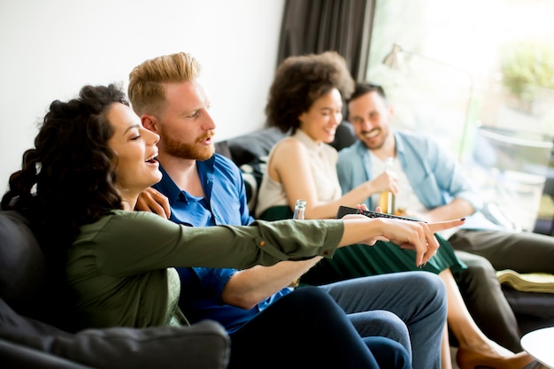 Foto grupo de amigos assistindo tv, bebendo cidra e se divertindo