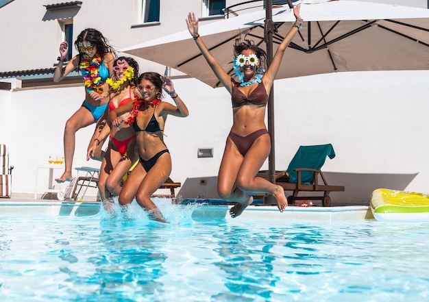 Foto grupo de amigos brincam juntos na piscina