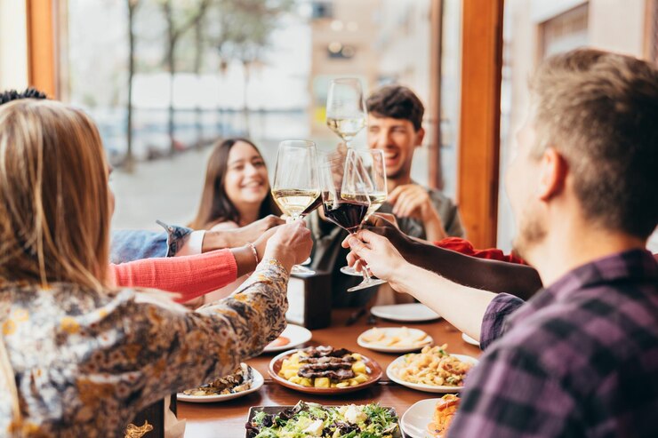 Grupo de amigos brindando com taças de vinho dentro de um restaurante Estilo de vida