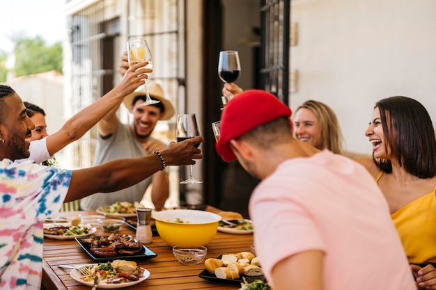 Grupo de amigos brindando enquanto come um churrasco