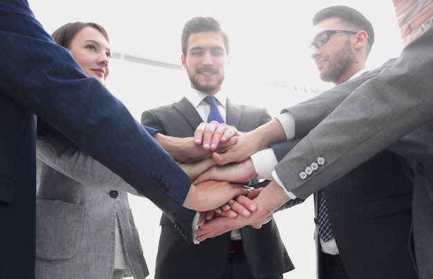 Grupo de amigos com as mãos no trabalho em equipe de pilha