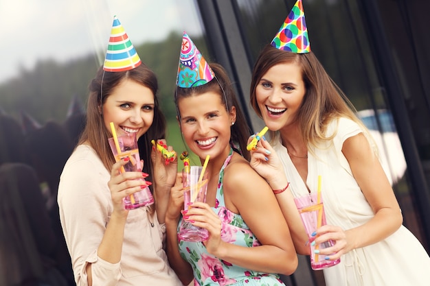 Grupo de amigos com assobios e bebidas comemorando aniversário