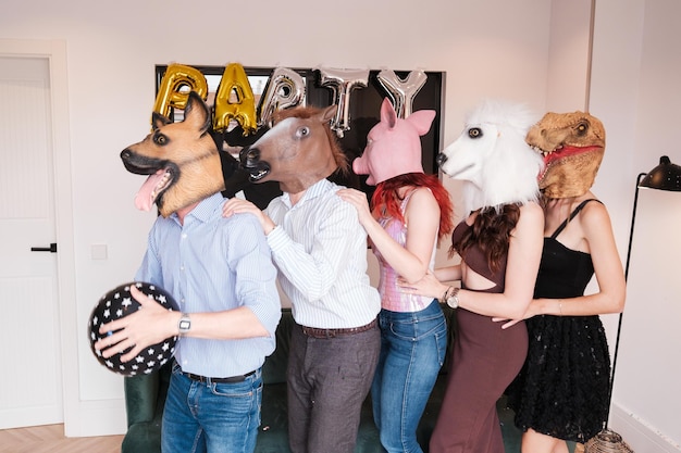 Foto grupo de amigos comemorando juntos com máscaras de animais em uma festa muito divertida estilo de vida de conceito