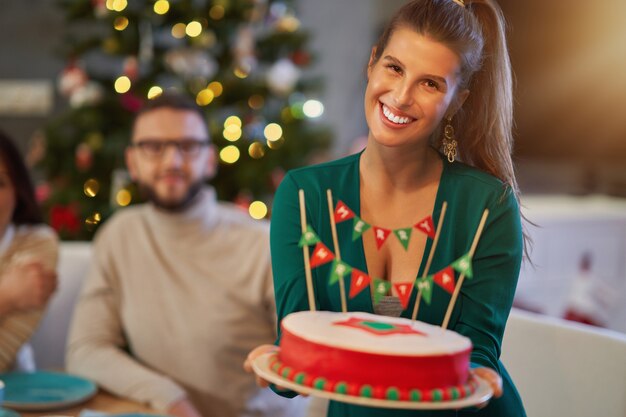 grupo de amigos comemorando o Natal em casa desfrutando de bolo x-mass