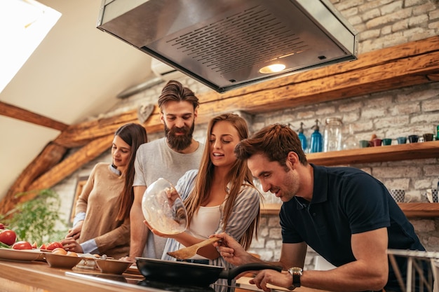 Grupo de amigos cozinhando juntos em casa