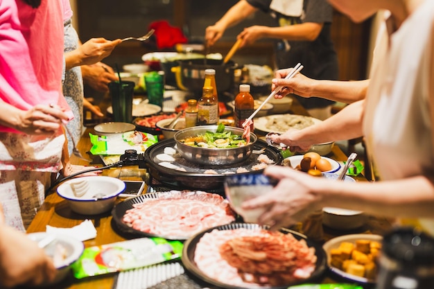 Grupo de amigos cozinhando o hotpot chinês shabu em casa