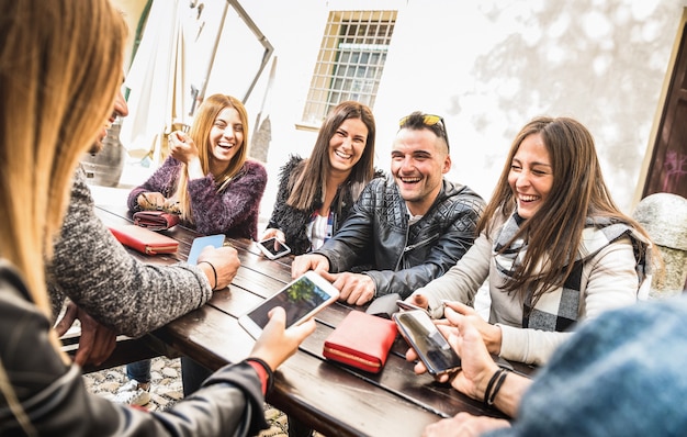 Grupo de amigos da geração Y se divertindo usando um smartphone móvel