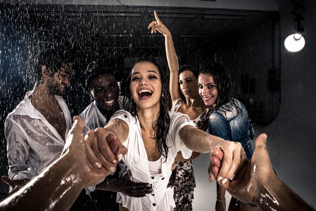 Grupo de amigos dançando na chuva