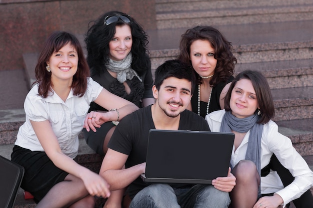 Grupo de amigos de alunos com um conceito de laptop.