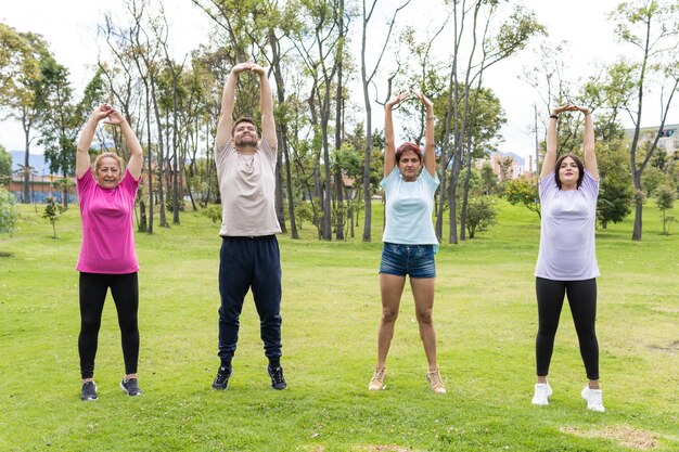 Grupo de amigos de diferentes idades se exercitando no parque