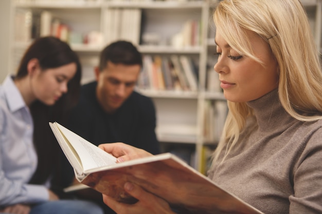 Grupo de amigos, desfrutando de estudar juntos na biblioteca