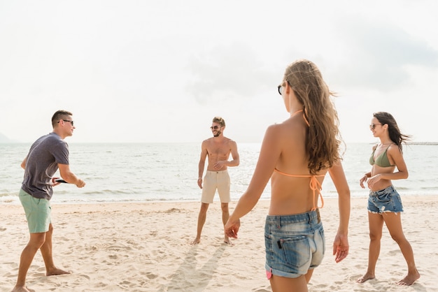 Grupo de amigos desfrutando jogando jogo de praia juntos