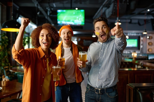 Grupo de amigos emocionais assistindo futebol no pub