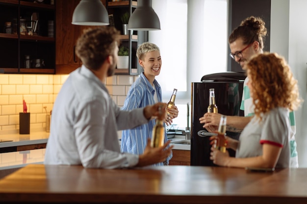 Grupo de amigos estão socializando e bebendo cerveja em casa