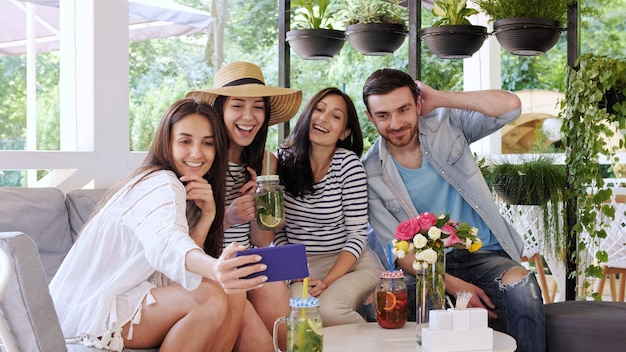 Grupo de amigos faz selfie no café.