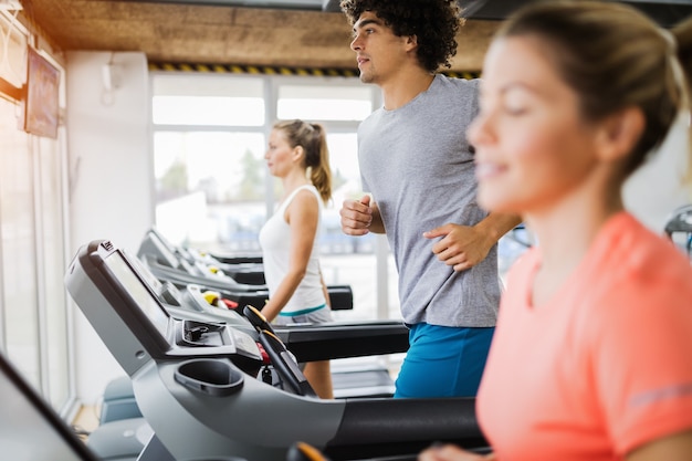 Grupo de amigos fazendo exercícios na esteira na academia