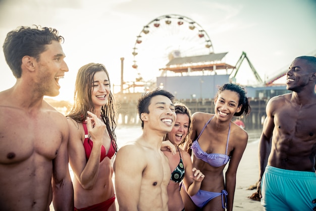 Grupo de amigos fazendo uma grande festa e jogos na praia