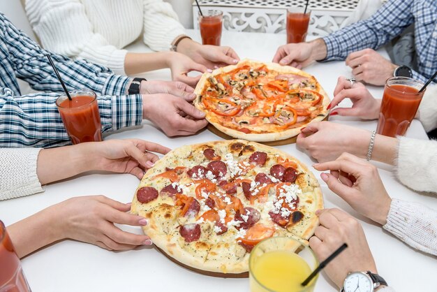 Grupo de amigos feliz em um café comendo pizza