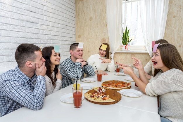 Grupo de amigos feliz em um café comendo pizza