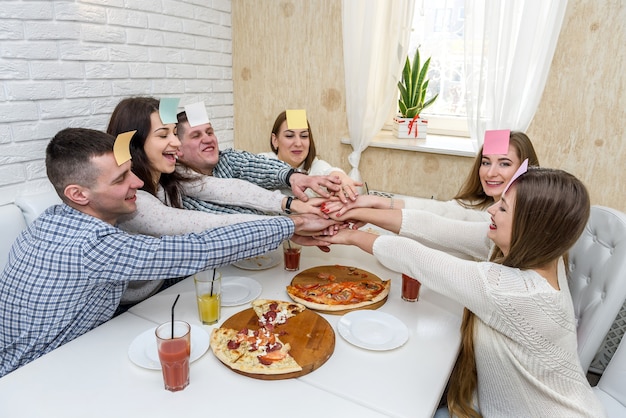 Grupo de amigos feliz em um café comendo pizza