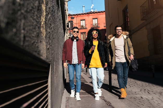 Grupo de amigos felizes andando na rua. Conceito de amizade.