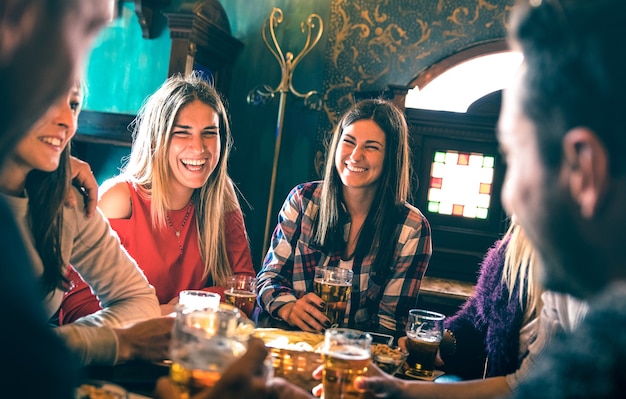 Grupo de amigos felizes bebendo cerveja em bar restaurante de cervejaria