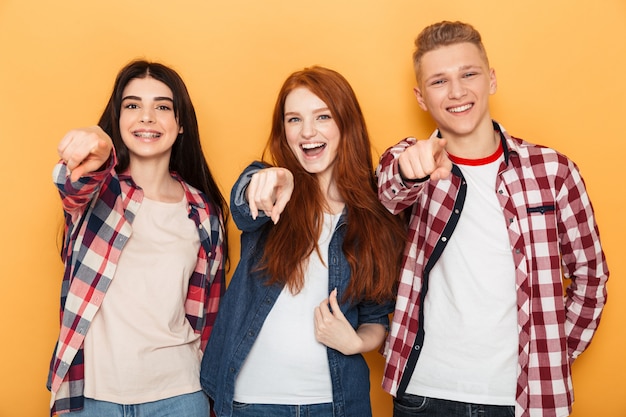 Foto grupo de amigos felizes da escola apontando o dedo