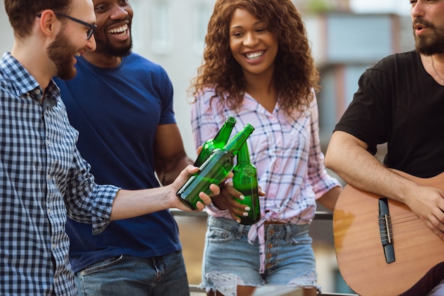 Grupo de amigos felizes em festa de cerveja no dia de verão, descansando juntos ao ar livre, comemorando e