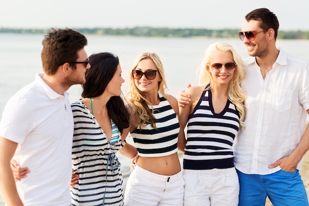 grupo de amigos felizes em roupas listradas na praia