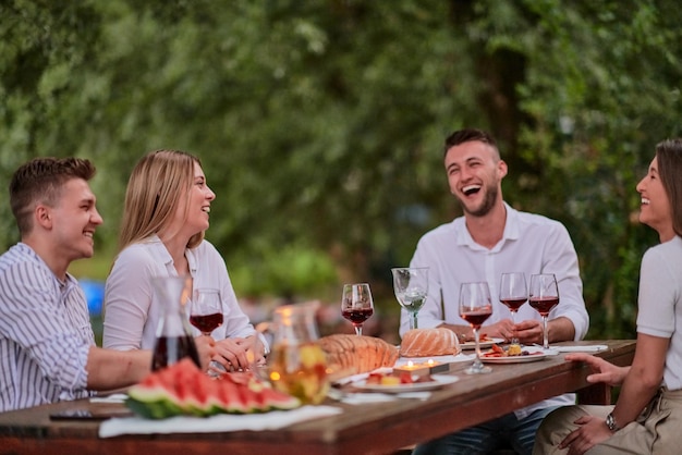 grupo de amigos felizes fazendo piquenique jantar francês ao ar livre durante as férias de verão perto do rio na bela natureza