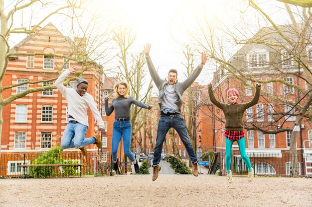 Grupo de amigos felizes pulando juntos no parque