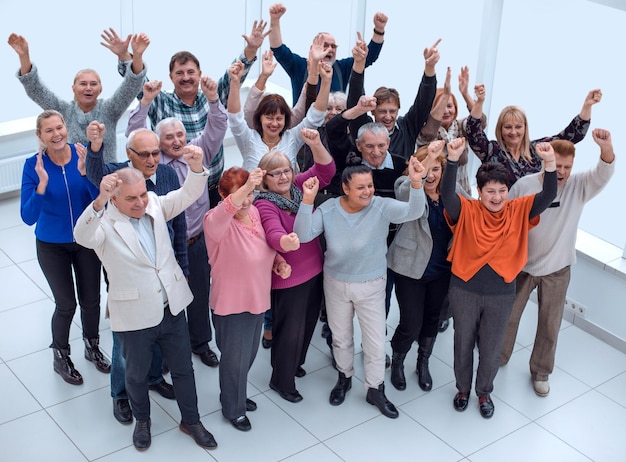 Grupo de amigos idosos levantou as mãos e comemora o sucesso