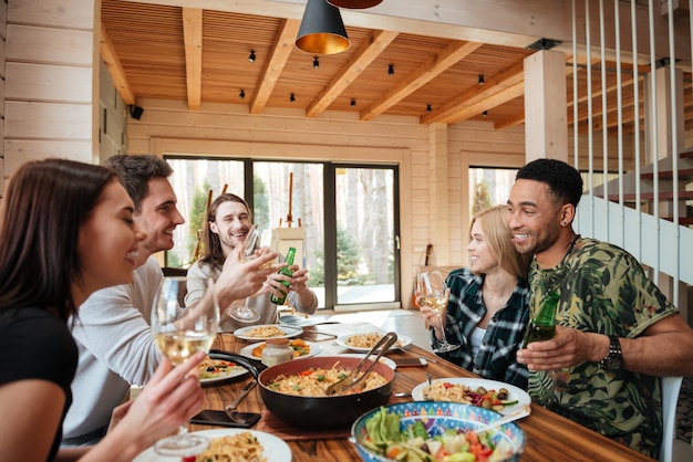 Grupo de amigos jantando e rindo na mesa