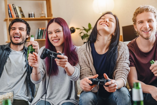 Grupo de amigos jogando videogame juntos em casa e se divertindo