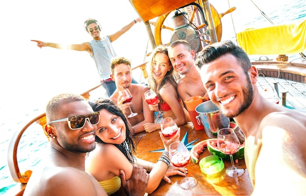 Grupo de amigos milenares multiculturais tomando selfie torcendo na festa do barco a vela