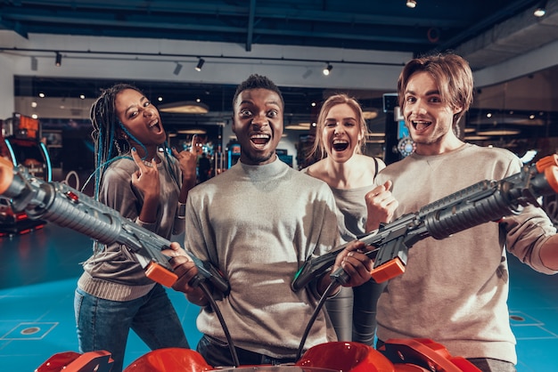 Foto grupo de amigos no arcade. cara com armas.