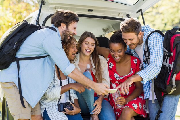 Grupo de amigos, olhando para o telefone móvel