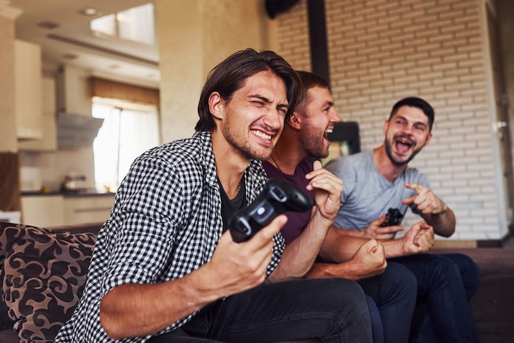 Foto grupo de amigos se divertem jogando videogame dentro de casa, na sala de estar.