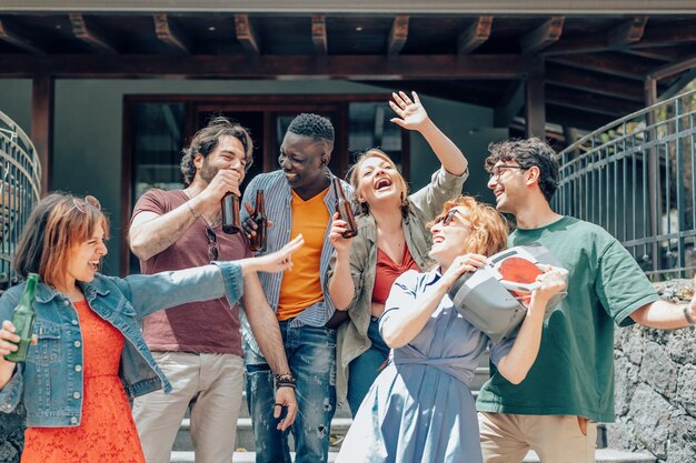 Grupo de amigos se divertindo com música estéreo antiga e bebidas