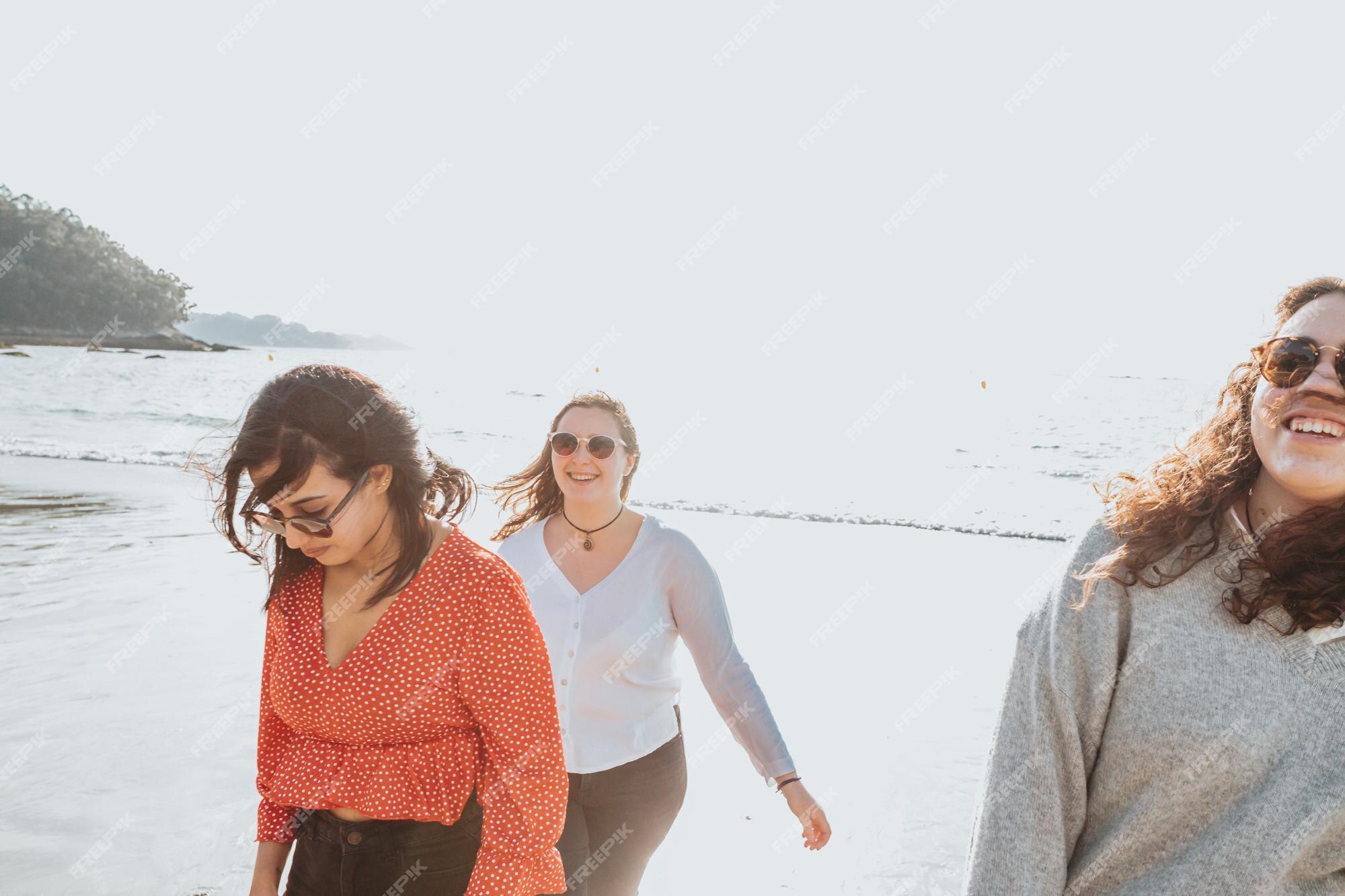 Grupo de amigos se divertindo, correndo juntos na praia de inverno.  multiétnico. todas as meninas do clube. três amigas rindo juntas - conceito  de amizade feminina. estilo de vida. fotografia freedom travel