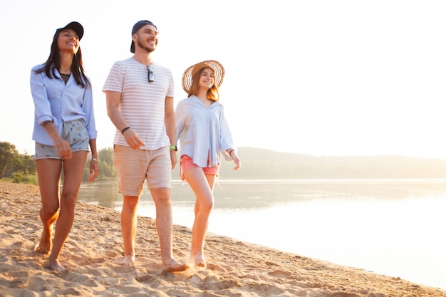 Grupo de amigos se divertindo correndo na praia - Juventude, estilo de vida de verão e conceito de férias